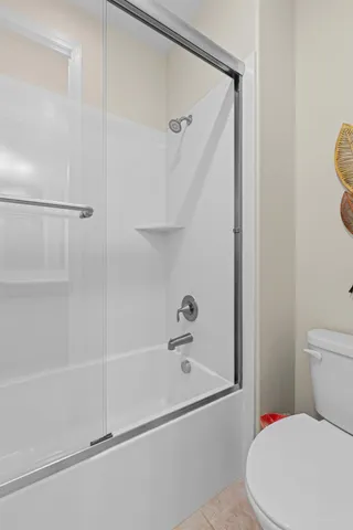 a white toilet sitting next to a bath tub