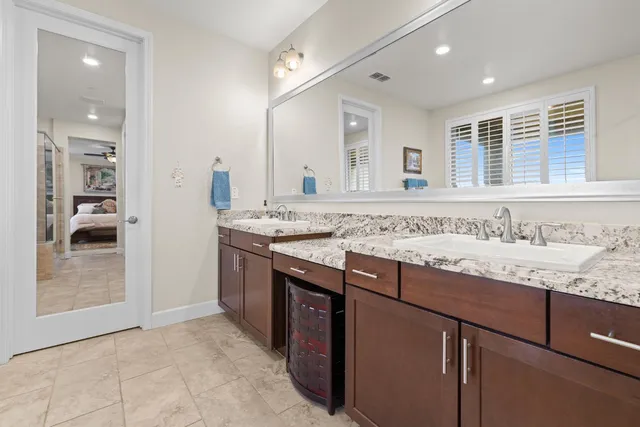 a bathroom with a granite countertop sink and a mirror