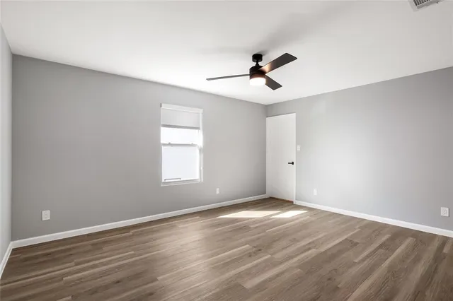 a view of room with hardwood floor and ceiling fan