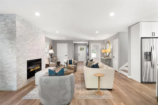 a living room with furniture a fireplace and a large window
