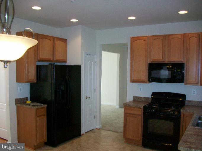 8705 Francesca Drive Clinton, MD 20735 - Photo 23 of 25 a kitchen with stainless steel appliances granite countertop a refrigerator and a microwave