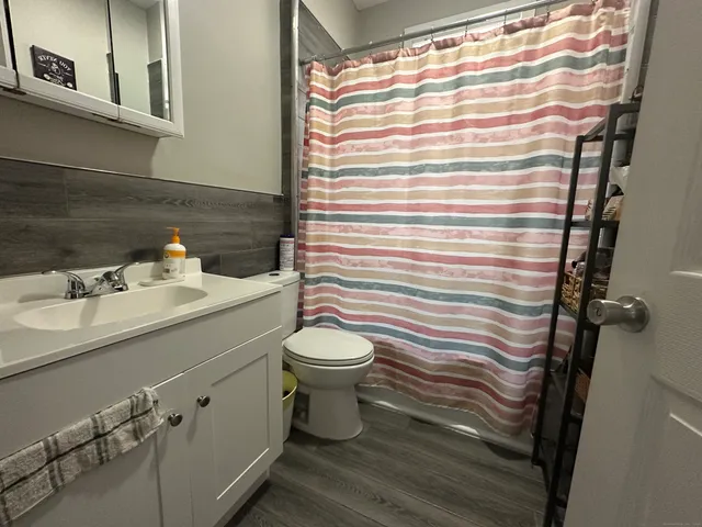 a bathroom with a sink a toilet and shower curtain
