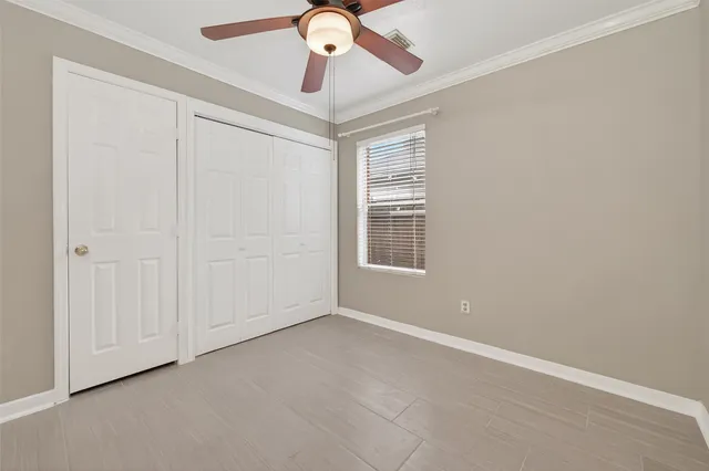 an empty room with windows and fan