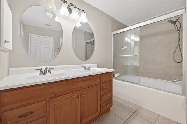 a bathroom with a tub a sink and mirror