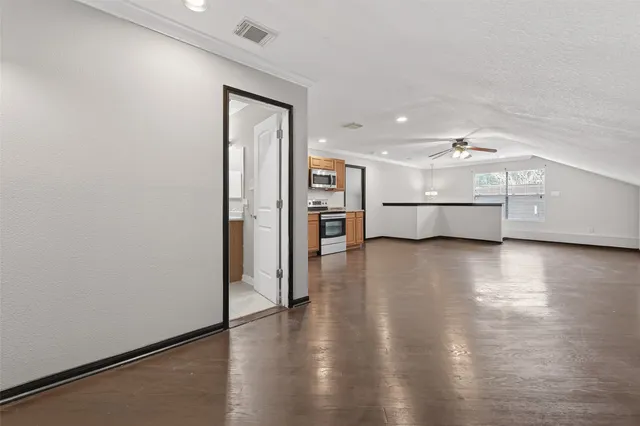 a view of a kitchen with a fridge and wooden floor