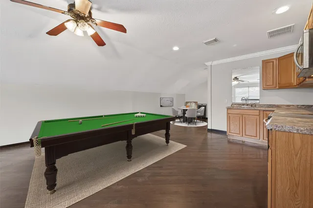 a room with pool table and windows