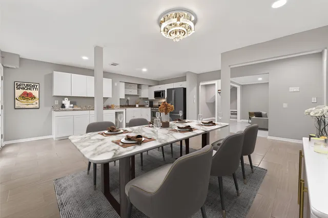 a dining room with stainless steel appliances a table and chairs