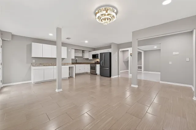 a view of kitchen with refrigerator and cabinets