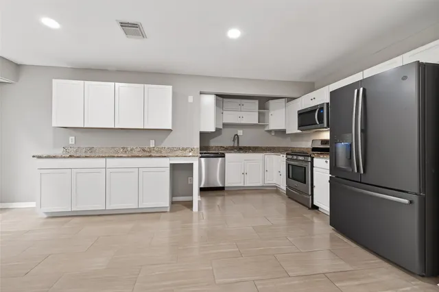 a kitchen with a refrigerator stove top oven and sink