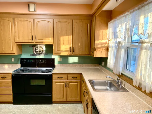 a kitchen with stainless steel appliances granite countertop a sink stove and cabinets