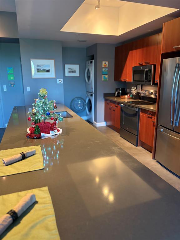 2301 Wilton Drive, Unit R309 Wilton Manors, FL 33305 - Photo 12 of 26 a kitchen with stainless steel appliances kitchen island granite countertop a stove and cabinets