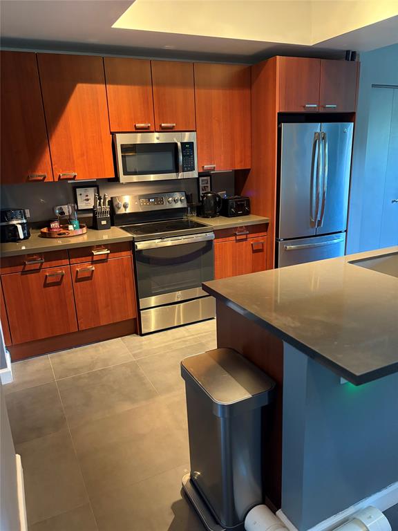 2301 Wilton Drive, Unit R309 Wilton Manors, FL 33305 - Photo 10 of 26 a kitchen with stainless steel appliances a stove a microwave and a sink