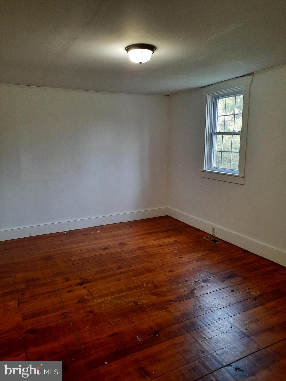 1515 River Road Drumore, PA 17518 - Photo 8 of 13 an empty room with wooden floor and windows