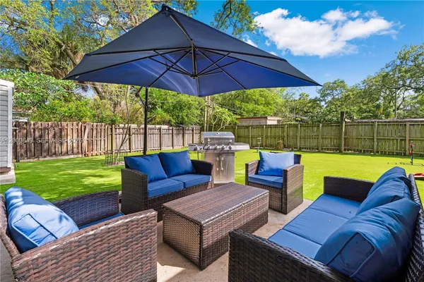 a view of a patio with couches chairs and a umbrella