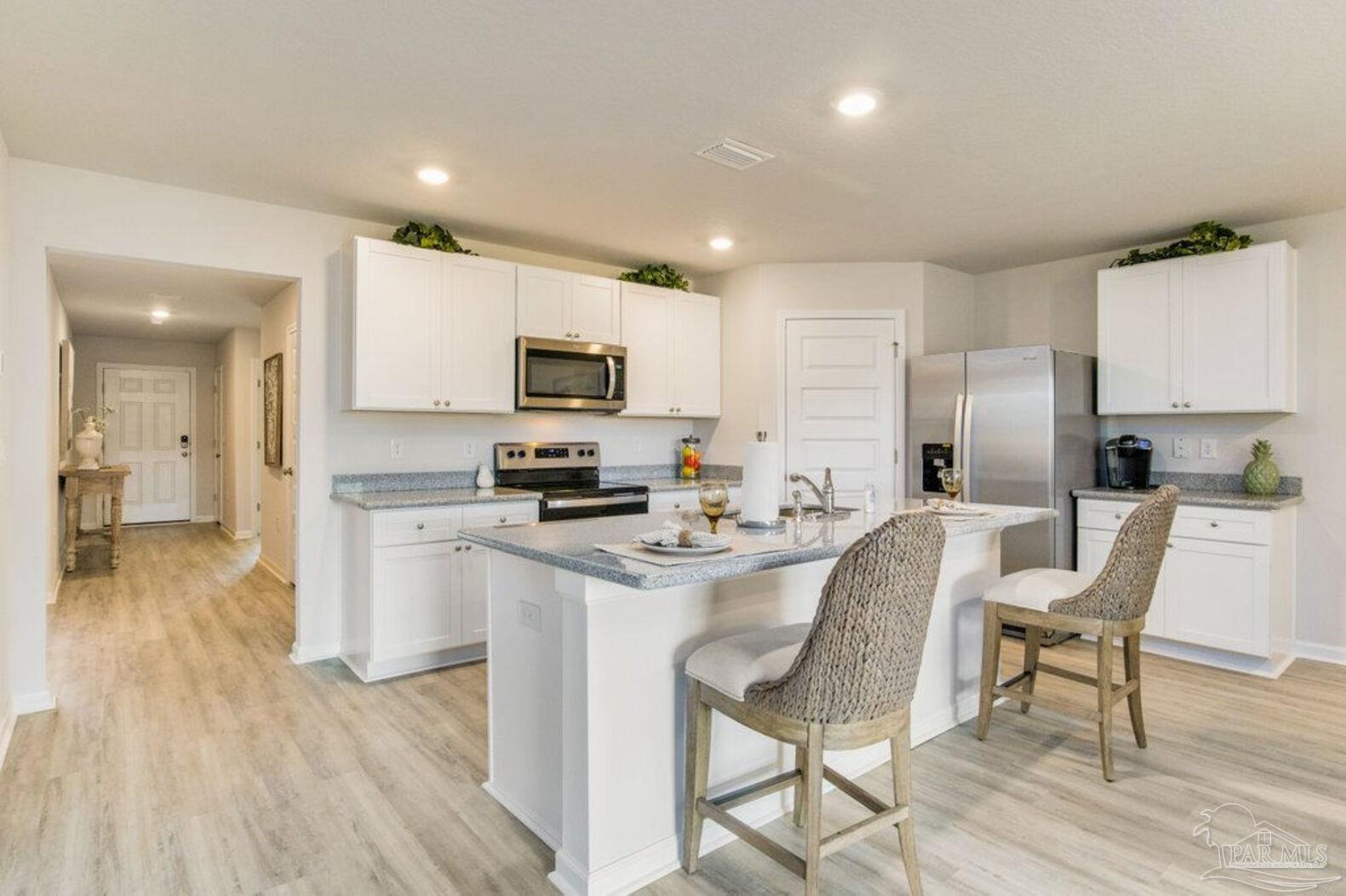 265 Monarch Lane Pensacola, FL 32503 - Photo 5 of 13 a kitchen with stainless steel appliances a microwave a stove a refrigerator a sink a dining table and chairs