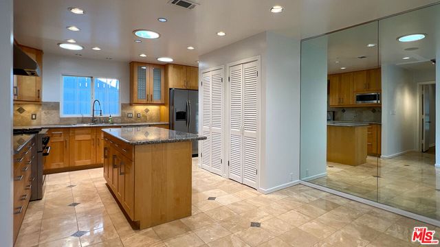 a kitchen with stainless steel appliances granite countertop a sink cabinets and wooden floor