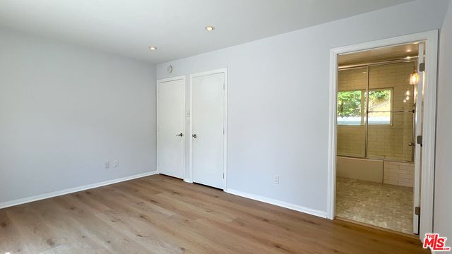a bathroom with a toilet a sink a glass door a shower and a mirror