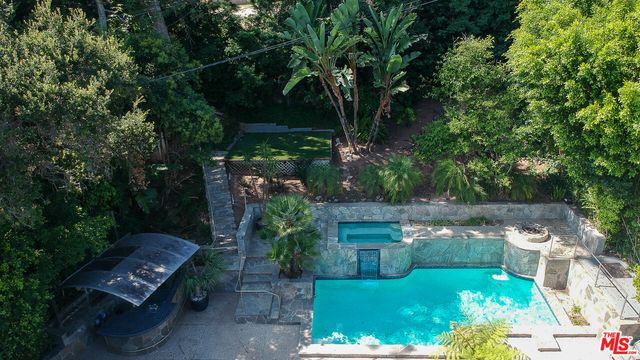 an aerial view of a house with a yard and trees all around