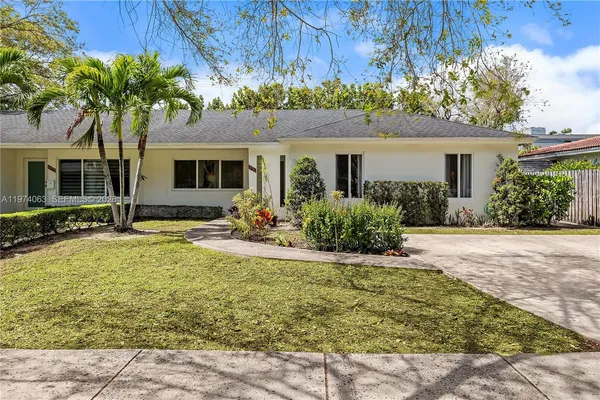 a front view of house with yard and trees around