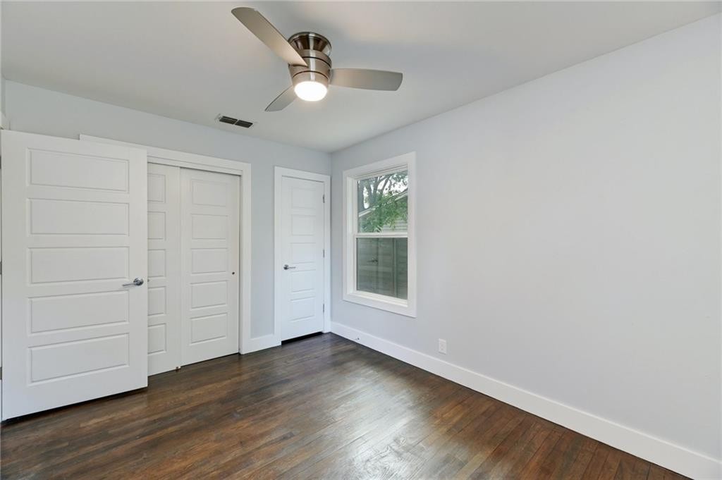 8318 Burrell Drive Austin, TX 78757 - Photo 14 of 27 Unfurnished bedroom featuring dark wood-style floors, a ceiling fan, and a closet