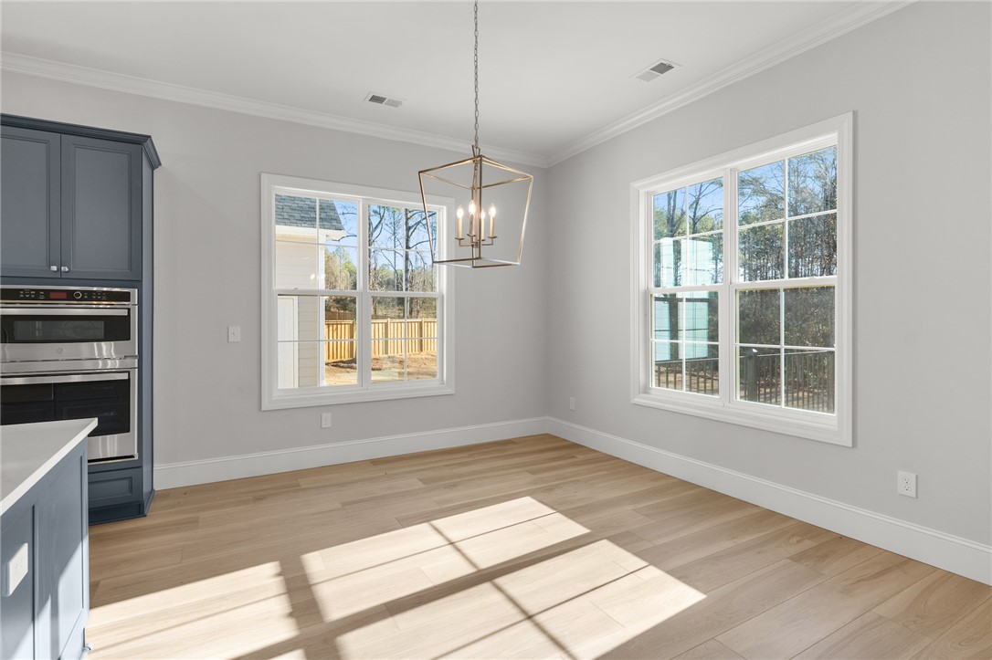 141 Rickys Path Easley, SC 29642 - Photo 14 of 40 Bright and open, this dining area features ample natural light and elegant hardwood floors.