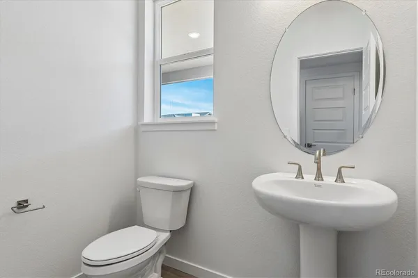 a bathroom with a toilet a sink and mirror
