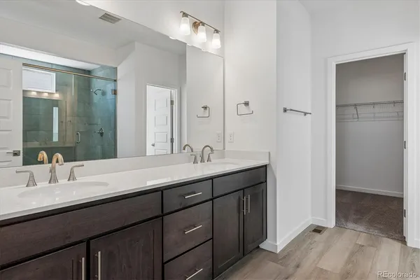a bathroom with double vanity sinks and a mirror