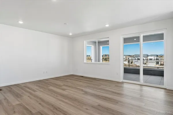 wooden floor in an empty room with a kitchen