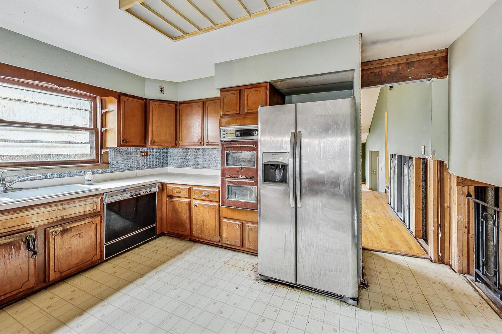 771 Ridge Road Highland Park, IL 60035 - Photo 15 of 54 a large kitchen with stainless steel appliances granite countertop a refrigerator a sink a stove and white cabinets with wooden floor
