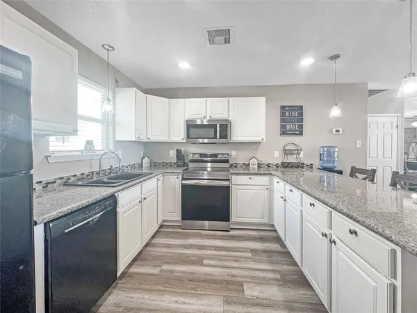a kitchen with granite countertop white cabinets and white appliances