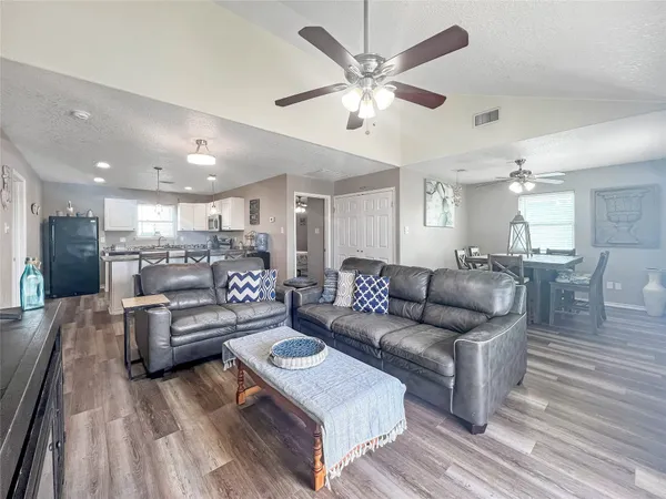 a living room with furniture and a view of kitchen