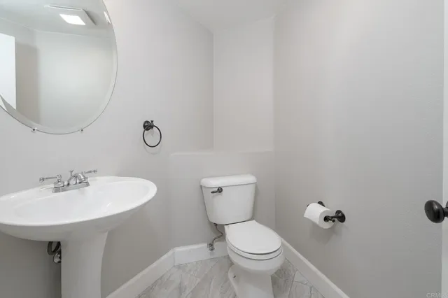 a bathroom with a toilet a sink and mirror