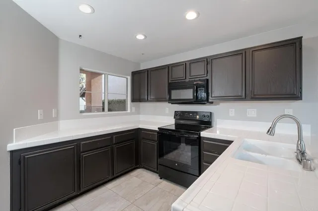 a kitchen with stainless steel appliances granite countertop a sink stove and microwave