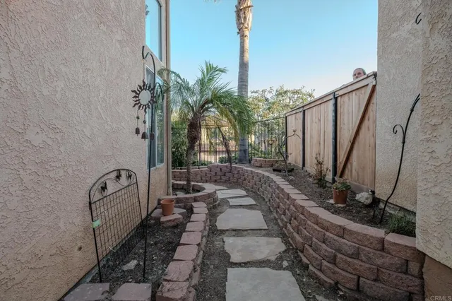 a view of a backyard with potted plants and large trees