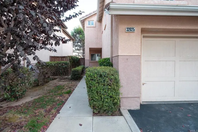 a backyard with potted plants and wooden wall