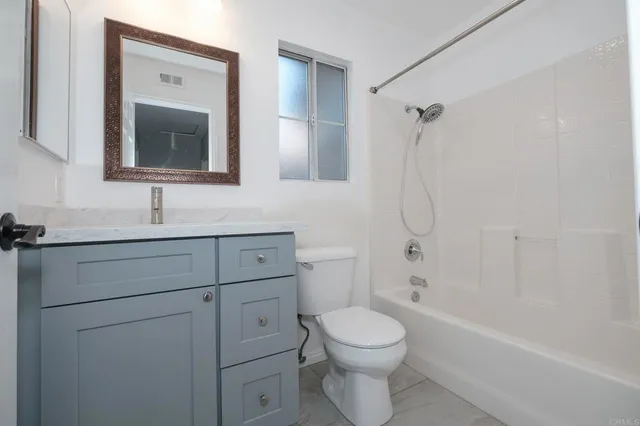 a bathroom with a toilet sink vanity tub and shower