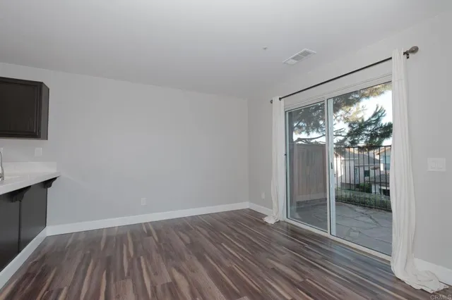 a view of hallway with wooden floor and fan