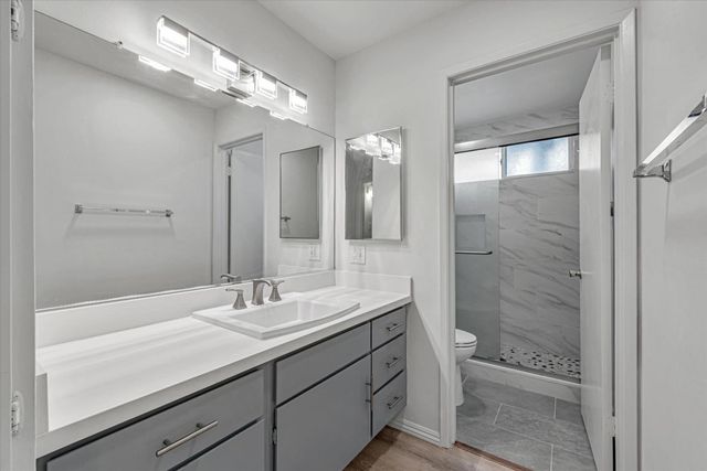 a bathroom with a shower sink and mirror