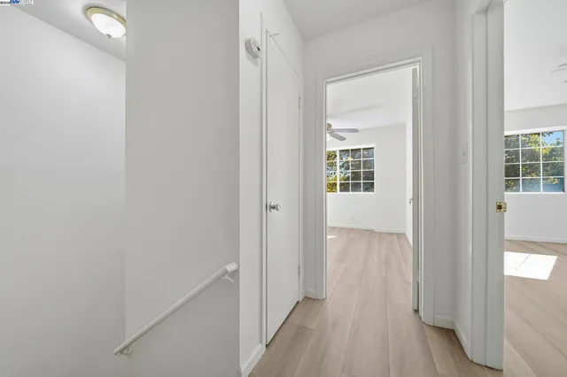 an empty room with windows and fan