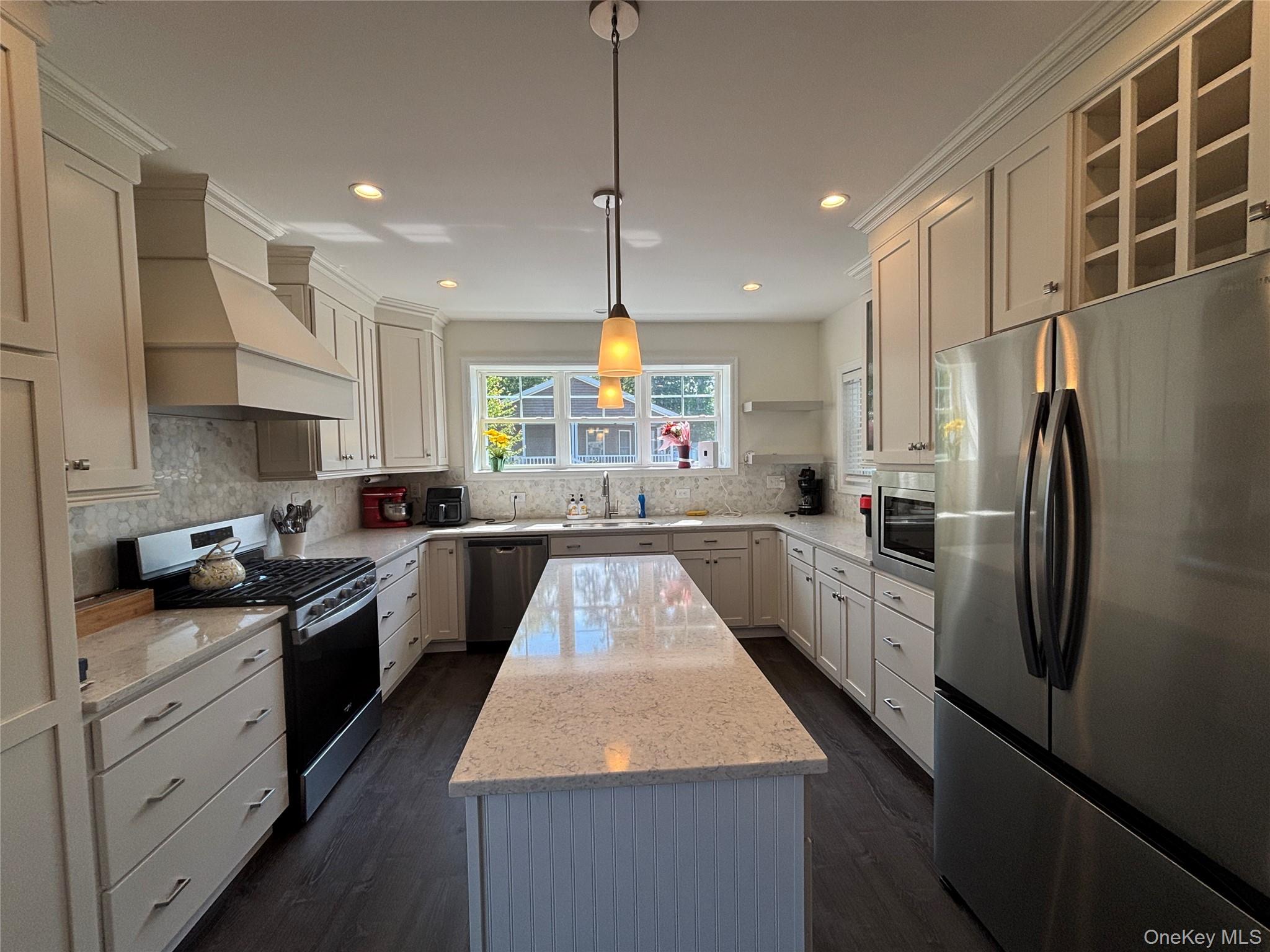 1661 Old Country Road, Unit 563 Riverhead, NY 11901 - Photo 12 of 43 a kitchen with stainless steel appliances granite countertop a refrigerator a sink dishwasher a stove and white cabinets with wooden floor