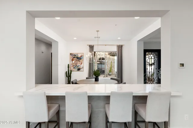 a living room with kitchen furniture a dining table and a floor to ceiling window