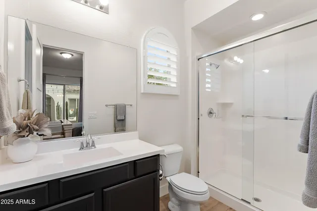 a hallway with white cabinets and wooden floor