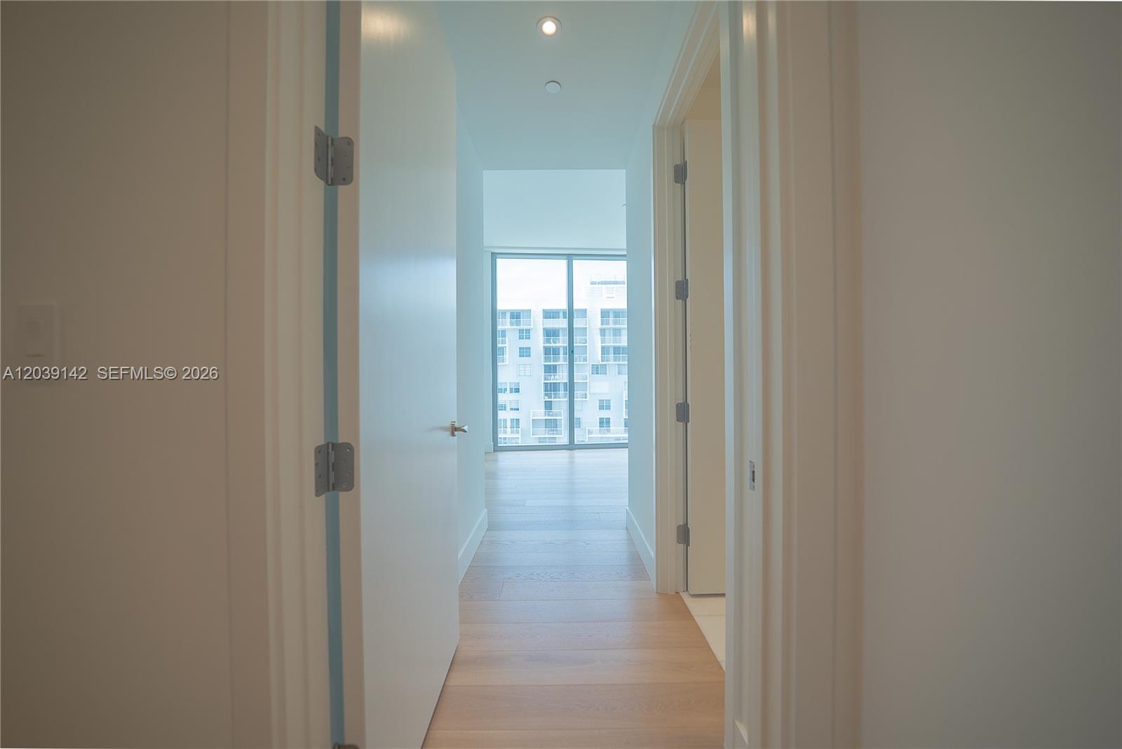 175 Southeast 25th Road, Unit 702 Miami, FL 33129 - Photo 24 of 30 a view of a hallway to an empty room with wooden floor and a window