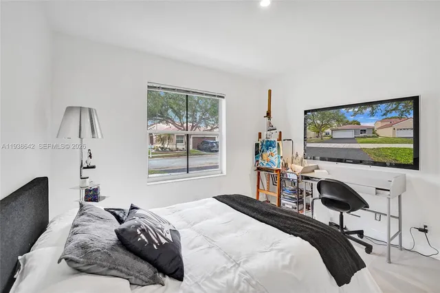 a living room with furniture a rug kitchen view and a large window