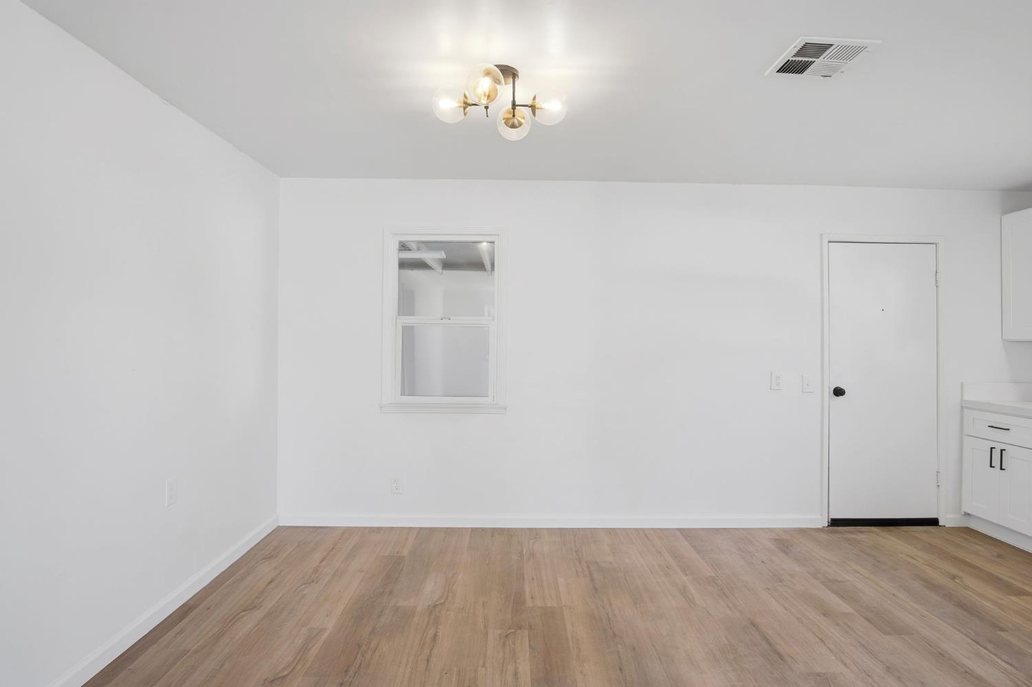 816 Dawn Drive Modesto, CA 95350 - Photo 12 of 22 a view of an empty room with wooden floor and a window
