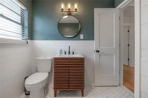 a bathroom with a sink a toilet a shower and a mirror