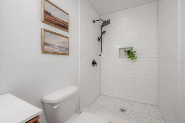 a bathroom with a bathtub sink vanity mirror and toilet