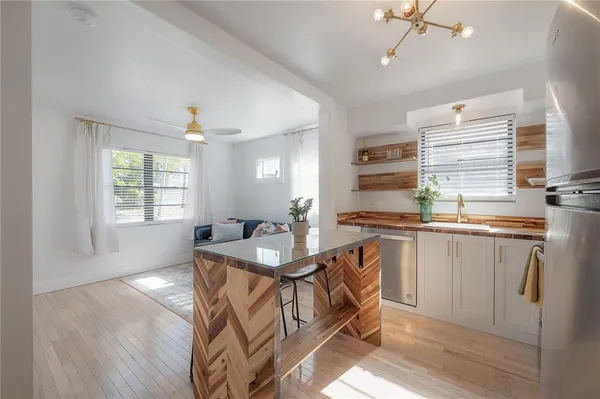 a view of a patio with table and chairs potted plants with wooden floor and fence