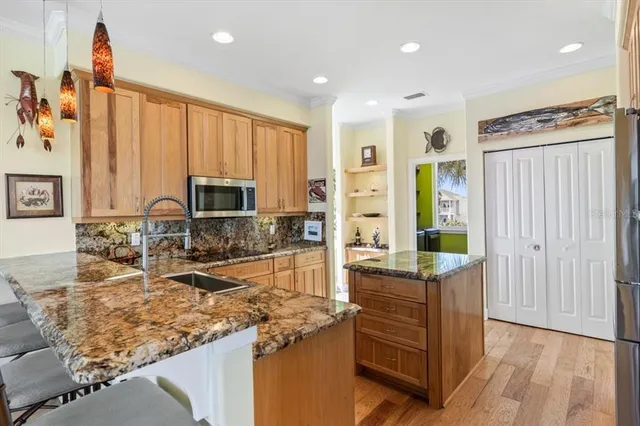a kitchen with stainless steel appliances granite countertop a refrigerator stove and sink