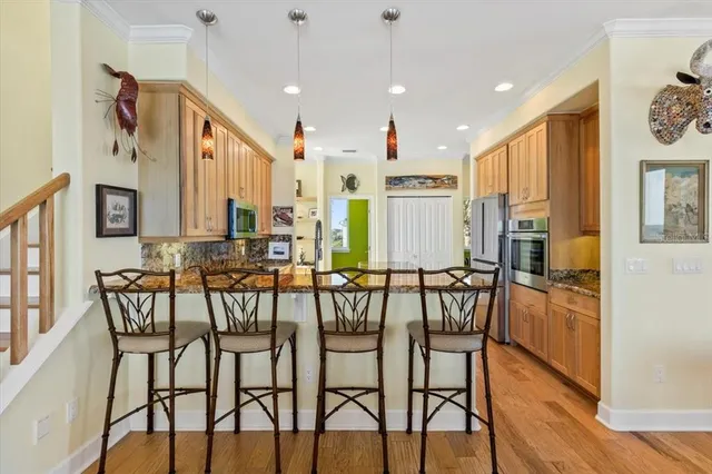 a living room with furniture kitchen view and a wooden floor